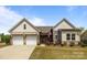 Charming home with a well-manicured lawn, brick accents, and a welcoming two-car garage at 8018 Green Heron Ct, Belmont, NC 28012