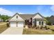 Charming home featuring a two-car garage, well-manicured landscaping, and a welcoming entrance with an American flag at 8018 Green Heron Ct, Belmont, NC 28012