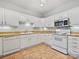 Well-lit kitchen features white cabinetry, stainless steel microwave, and tan countertops at 8274 Windsor Ridge Dr, Charlotte, NC 28277