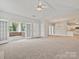 Open living room features a ceiling fan, access to kitchen, and enclosed patio at 8274 Windsor Ridge Dr, Charlotte, NC 28277