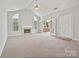 Bright living room features a fireplace, carpet, and access to outdoor patio at 8274 Windsor Ridge Dr, Charlotte, NC 28277