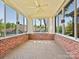 Sunroom features large windows, brick accents, and ceiling fan at 8274 Windsor Ridge Dr, Charlotte, NC 28277