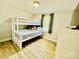 Bedroom featuring a bunk bed, wood floors, a dresser, and a window with natural light at 9007 Mcmillian Dr, Harrisburg, NC 28075