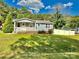 Charming single-story home featuring a welcoming front porch and well-maintained lawn on a sunny day at 9007 Mcmillian Dr, Harrisburg, NC 28075