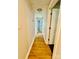 Well-lit hallway featuring wood flooring and multiple doorways, creating an open and accessible layout at 9007 Mcmillian Dr, Harrisburg, NC 28075