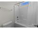 Bright bathroom featuring a shower and tub combo with a window, alongside a low-flow toilet at 9494 Leyton Dr, Harrisburg, NC 28075