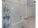 Well-maintained bathroom features a shower-tub with a curtain, with an open door showing the bedroom at 9494 Leyton Dr, Harrisburg, NC 28075