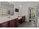 Primary bathroom with dual sinks, modern fixtures, and a separate glass-enclosed shower at 9494 Leyton Dr, Harrisburg, NC 28075