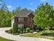 Charming two-story brick home with lush landscaping and a manicured lawn at 9494 Leyton Dr, Harrisburg, NC 28075