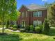 Daytime view of a charming two-story brick home with landscaped front yard and double-door entry at 9494 Leyton Dr, Harrisburg, NC 28075