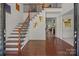Open foyer with hardwood floors, staircase with iron railings, and view into other living spaces at 9494 Leyton Dr, Harrisburg, NC 28075