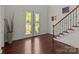 Elegant foyer featuring hardwood floors, a staircase with decorative iron railings, and a stained-glass front door at 9494 Leyton Dr, Harrisburg, NC 28075