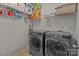 Well-organized laundry area with modern washer and dryer, plus shelving filled with household goods at 9494 Leyton Dr, Harrisburg, NC 28075