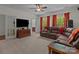 Comfortable living room featuring large sectional, TV, and bright windows with a view at 9494 Leyton Dr, Harrisburg, NC 28075