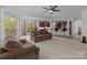 Open-concept living room with view into the kitchen, featuring plush seating and ample natural light at 9494 Leyton Dr, Harrisburg, NC 28075