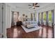 Spacious main bedroom featuring tray ceiling, ceiling fan, hardwood floors, and three large windows at 9494 Leyton Dr, Harrisburg, NC 28075
