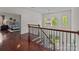Staircase with wood and iron railings, chandelier, and natural light flowing through transom windows at 9494 Leyton Dr, Harrisburg, NC 28075