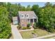 Expansive aerial view of a brick home surrounded by mature trees, and a long driveway with an attached garage at 9810 Daufuskie Dr, Charlotte, NC 28278