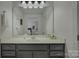 Bathroom features a vanity with cabinet storage, large mirror, and modern fixtures at 9810 Daufuskie Dr, Charlotte, NC 28278