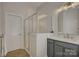 This bathroom features a white shower with glass enclosure, and a white vanity with gray cabinets at 9810 Daufuskie Dr, Charlotte, NC 28278