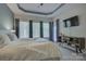 This neutral bedroom suite features a tray ceiling, wall-mounted television, and bright windows with shades at 9810 Daufuskie Dr, Charlotte, NC 28278