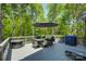 Outdoor deck with dining area, seating, and a lush, wooded backyard at 9810 Daufuskie Dr, Charlotte, NC 28278