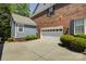 Home exterior displays brick and siding, a garage, and manicured landscaping around the driveway at 9810 Daufuskie Dr, Charlotte, NC 28278