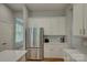 Kitchen with stainless steel refrigerator, white cabinets, and a view to the breakfast area at 9810 Daufuskie Dr, Charlotte, NC 28278