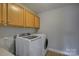 Functional laundry room equipped with a washer, dryer, and storage cabinets at 9810 Daufuskie Dr, Charlotte, NC 28278