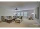 Spacious living room with a large sectional, ceiling fan, and bright windows at 9810 Daufuskie Dr, Charlotte, NC 28278
