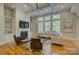Bright living room featuring a fireplace, built-in shelving, and large windows overlooking a wooded backyard at 9810 Daufuskie Dr, Charlotte, NC 28278