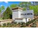 Stone monument sign for Bella Vista community surrounded by lush landscaping and mature trees at Lot#83 Northwood Ct, Denver, NC 28037