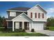 Charming two-story home featuring stone accents, dark siding, shingle accents, and a two-car garage at Lot#83 Northwood Ct, Denver, NC 28037