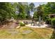 Backyard with stone patio, mature trees, and a refreshing in-ground pool at 10316 Whitethorn Dr, Charlotte, NC 28277