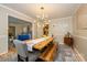 Bright dining room features a wooden table, bench seating, and modern lighting fixture at 10316 Whitethorn Dr, Charlotte, NC 28277