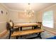 Charming dining room featuring a rustic table, bench seating and modern light fixture at 10316 Whitethorn Dr, Charlotte, NC 28277
