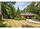Charming brick home featuring a well-manicured lawn, mature trees, and a covered carport at 10316 Whitethorn Dr, Charlotte, NC 28277