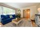 Bright living room with large windows, blue sofa and wood flooring at 10316 Whitethorn Dr, Charlotte, NC 28277
