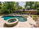 Inviting backyard oasis with a stunning pool, spa, and lush landscaping for outdoor relaxation at 10316 Whitethorn Dr, Charlotte, NC 28277