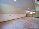 Attic featuring neutral carpet and paint, as well as a half wall with a wooden railing at 110 Dutch Creek Rd, Rockwell, NC 28138
