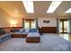 Cozy living room featuring plush carpet, wood paneling, skylights, and a comfortable sectional sofa at 110 Dutch Creek Rd, Rockwell, NC 28138