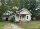 Charming single-story home featuring a covered porch, mature trees, and a detached garage at 110 E Church St, Dallas, NC 28034