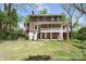 Brick home showcasing an outdoor porch, staircase, and expansive grassy area, ideal for outdoor entertaining at 122 Corban Se Ave, Concord, NC 28025