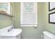 Small bathroom with decorative glass window, a pedestal sink, toilet and framed art at 122 Corban Se Ave, Concord, NC 28025