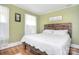 Bright bedroom featuring wood floors, natural light, and a wooden headboard at 122 Corban Se Ave, Concord, NC 28025
