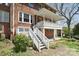 Rear exterior showcasing a brick facade, white-railed porch, and landscaped yard, perfect for outdoor living at 122 Corban Se Ave, Concord, NC 28025