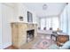 Bright living room with a brick fireplace and window seat, featuring natural light and hardwood floors at 122 Corban Se Ave, Concord, NC 28025