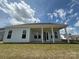Spacious backyard featuring a covered patio, lush green lawn, and blue skies at 13279 Arnold Palmer Cir # 867, Lancaster, SC 29720