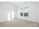 Neutral carpet and bright white trim are features of this bedroom with a large window at 13279 Arnold Palmer Cir # 867, Lancaster, SC 29720