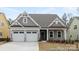 Charming home with a two-car garage, stone accents, and inviting front porch at 13279 Arnold Palmer Cir # 867, Lancaster, SC 29720